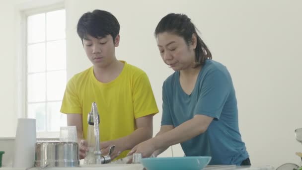 幸せな家族の母親と息子の料理一緒に笑顔で家で洗濯 — ストック動画