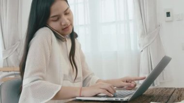 Zeki Asyalı genç girişimci iş kadını Sme 'nin sahibi evde çalışan dizüstü bilgisayarı konuşuyor ve kaydediyor. Ev ofis kavramında küçük işletme sahibi.