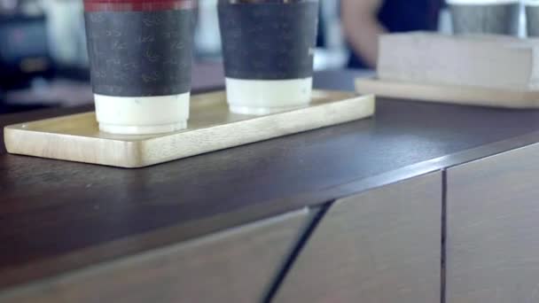 アジアスタイルのカフェでプラスチック製のわらとアイスコーヒーのカップ — ストック動画