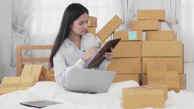 Asyalı Kardeşler müşterilere teslim edilmesi gereken eşyaların listesini inceliyor. Evde, Sme, yeni iş konsepti.