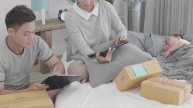 Asyalı aileler müşterilere teslim edilmesi gereken ürünlerin listesini kontrol ediyorlar. Kızım yanımda uyurken....