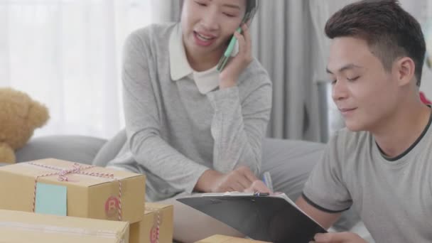 Asyalı Aileler Müşterilere Teslim Edilmesi Gereken Ürünlerin Listesini Kontrol Ediyorlar — Stok video