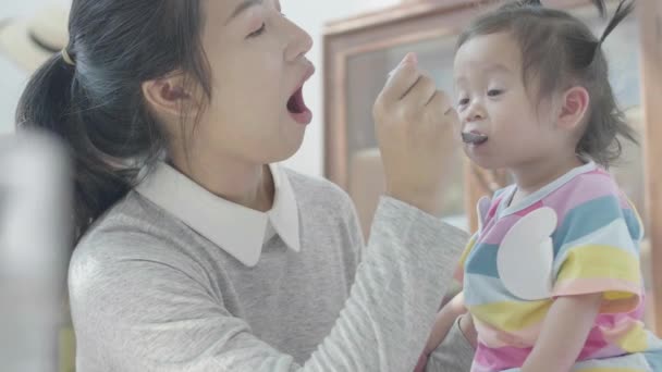 Ασιάτες Γονείς Ταΐζουν Γεύμα Της Κόρης Τους Στο Τραπέζι Του — Αρχείο Βίντεο