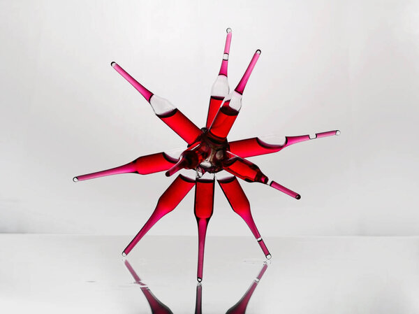 Стеклянные ампулы с красным лекарством витамин b12 склеенный в форме паука на стеклянной полке лаборатории
