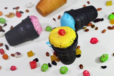 Fıstıklı çikolatalı dondurma, kurutulmuş meyveler ve masaya saçılmış karamel şekerleri serpiştirilmiş waffle kabı.