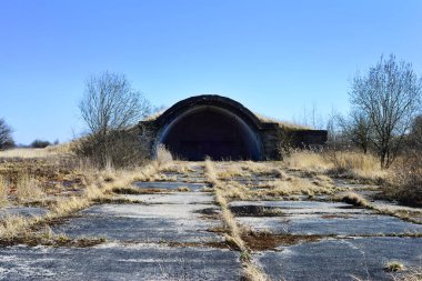 Terk edilmiş uçak hangarı askeri manzaralı eski bir havaalanı.
