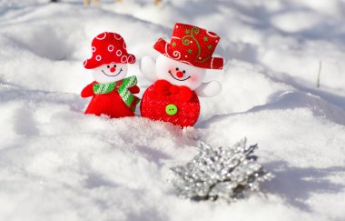 Yumuşak gülümseyen kartopu kız ve erkek beyaz kar arka plan üzerinde bir çift. Kardan adam karı koca Noel tatili üzerinde yan yana mutlu.