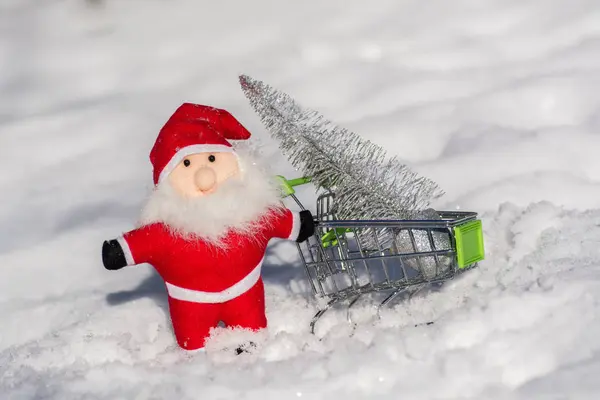 サンタ クロースは 休日のため カートに銀色のツリーを運んでいます クリスマスのグリーティング カード メリー クリスマスと新年あけましておめでとうございます — ストック写真