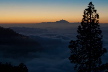 Integral Integral Inagua Doğal Rezervi, bulutlar denizi ve gün batımında Tenerife adası.