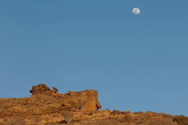 Луна над пустынным пейзажем на закате. — стоковое фото