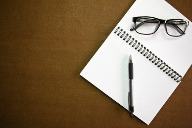 İş amaçlı aksesuarları üstünde okul sırası: defter, kalem, bardak. Vig ile