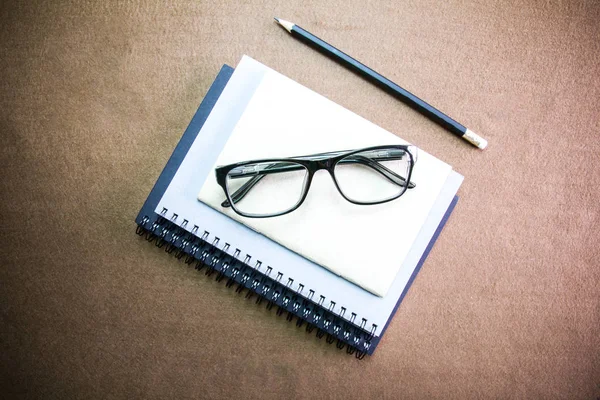 Accessoires d'affaires sur bureau : cahier, crayon, lunettes. Avec — Photo