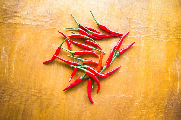 Ahşap arka planda kırmızı kırmızı kırmızı biber.