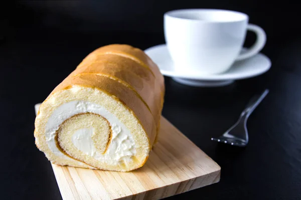 Rulltårta och kaffe på trä bakgrund. — Stockfoto