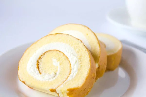 Swiss roll and coffee on white background. — Stock Photo, Image