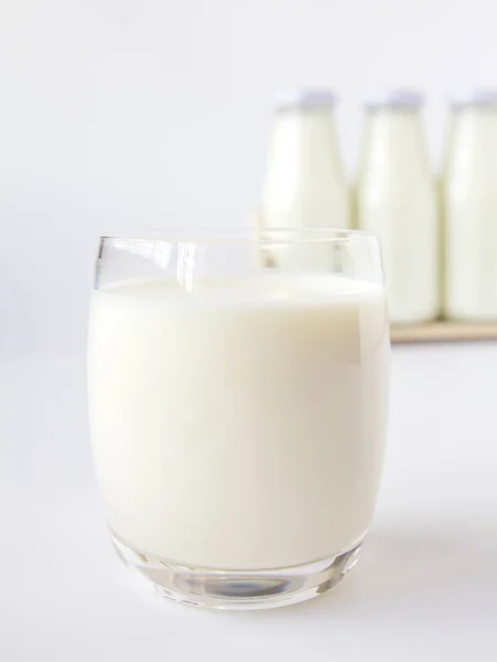 Μπουκάλι γάλα και ποτήρι γάλα σε λευκό φόντο — Φωτογραφία Αρχείου