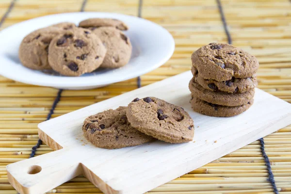 Chocolate Chip Cookies on chopping wood and white plate — Stock Photo, Image