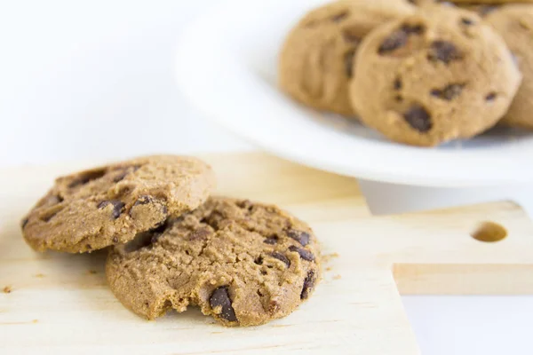 Chocolate Chip Cookies on chopping wood and white plate — Stock Photo, Image