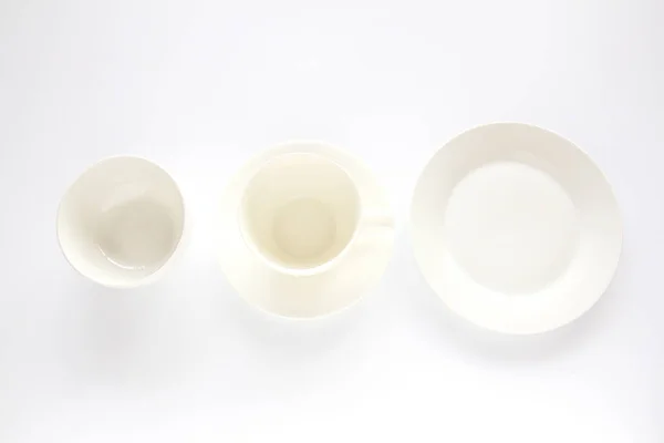 Assiette blanche vide, tasse blanche et bol blanc sur fond blanc — Photo