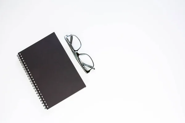 Notebook en bril op witte achtergrond. — Stockfoto