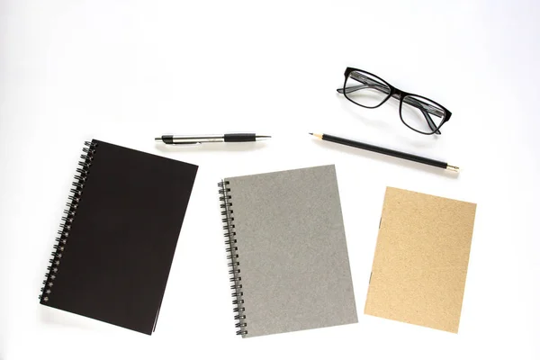 Notebook, pen, potlood en glazen op witte achtergrond. — Stockfoto