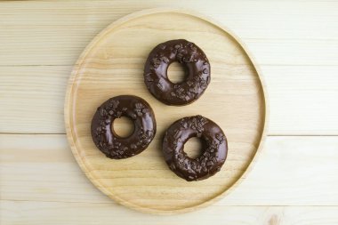 Çikolatalı Donuts ahşap arka plan üzerinde ahşap plaka üzerinde