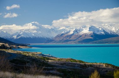 Kar, önplanda Pukaki Gölü ile Cook Dağı 'nı kapladı ve mavi gökyüzü ve beyaz bulutlar, Güney Adası, Yeni Zelanda
