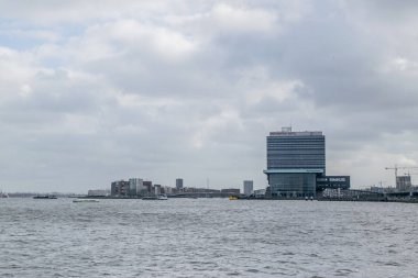 AMSTERDAM, NETHERLANDS - Şubat 2020: Hollanda 'nın Kuzey Hollanda bölgesindeki Amsterdam şehrindeki IJ nehri