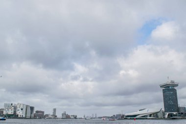 AMSTERDAM, NETHERLANDS - Şubat 2020: Hollanda 'nın Kuzey Hollanda bölgesindeki Amsterdam şehrindeki IJ nehri