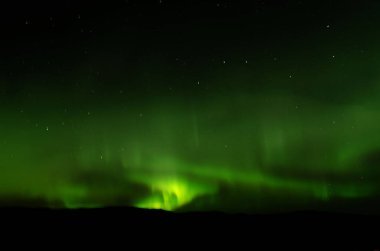 İnanılmaz aurora borealis, İzlanda 'da yapılmış, inanılmaz desenler gökyüzünü kaplıyor, yeşil ışık alışılmadık şekillerde oynuyor.
