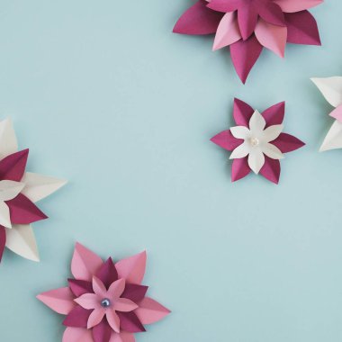 Açık arkaplanda renkli kağıt çiçekler. Pastel renklerde en düşük bileşim. Bahar ya da yaz dönemi. Üst görünüm, düz görünüm, kopyalama alanı