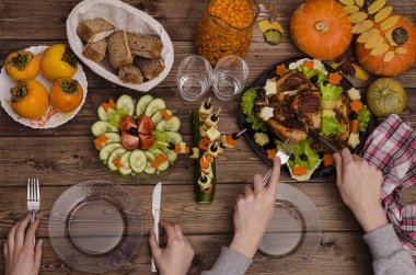 Tavuklu Şükran Günü yemeği, taze sebzeler, dikenli deniz dikenleri. Gala yemeğinde evli bir çift, bir adam tavuk kesiyor.. 