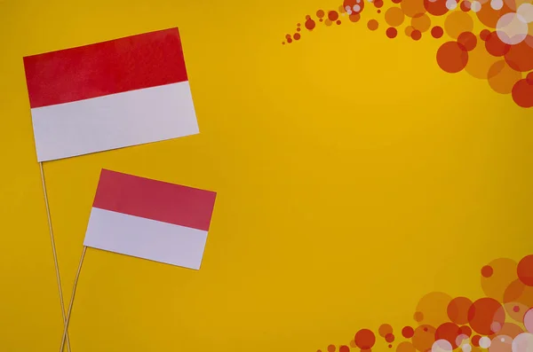 Indonesia Independence Day. Flags of Indonesia on a yellow background with copy space with multi-colored bokeh.
