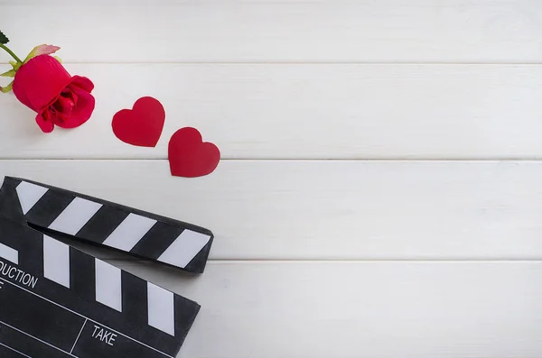 Cinéma le jour de la Saint Valentin. Publicité au cinéma. Panneau de battage de cinéma avec des cœurs et une rose sur un fond en bois blanc . — Photo