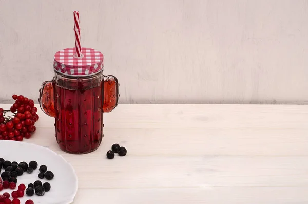 Czerwony napój herbaciany w słoiku ze słomką z jagód na białym drewnianym tle z przestrzenią do kopiowania. Napój witaminowy w celu poprawy odporności. — Zdjęcie stockowe