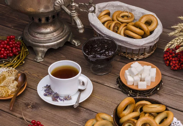 Russian tea. Tea ceremony with a samovar. Ivan tea with honey, with bagels on a dark wooden background. Spring, Shrovetide.