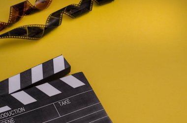 Alkış tahtası ve film şeridi fotokopi alanı olan parlak sarı bir arkaplanda. Film hakkındaki makaleler için..
