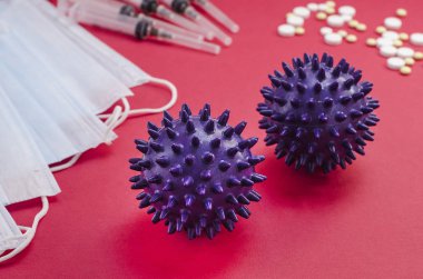 Virüs hücresi, haplar, maskeler, kırmızı arka planda şırıngalar. Koronavirüsün yayılması. Viral enfeksiyon. 