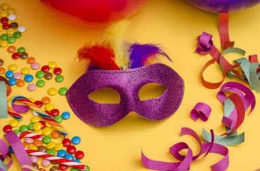 Karnaval. Fotokopi alanı olan şenlikli bir arka plan. Karnaval maskesi mor, sarı arka planda tüyleri var. Süslü, çok renkli şekerleri var. Mardi Gras 'da. Brezilyalı. Venedik.
