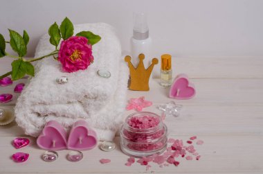 Kraliyet spa prosedürü, hediye olarak masaj. Beyaz havlu, mumlar, tuz, beyaz arka planda fotokopi alanı olan bir dekor olarak çiçekler. Stres önleyici ve detoks tedavisi. Güzellik salonları için.