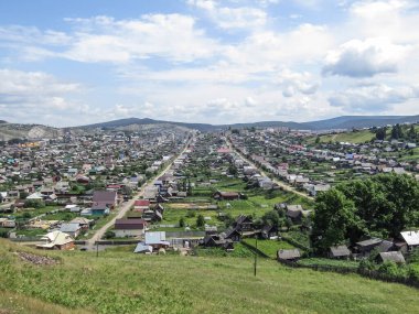 Dağdan evlere, köye bak. Doğal yaz manzarası. Mavi gökyüzüne karşı güzel manzara.