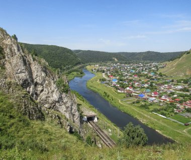 Dağdan evlere, köye bak. Doğal yaz manzarası. Mavi gökyüzüne karşı güzel manzara.