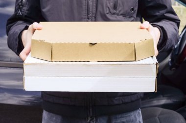 Kurye pizzayı arabayla teslim etti. Yemek servisi. Teslimatçı. Koronavirüs karantinası sırasında güvenli teslimat.