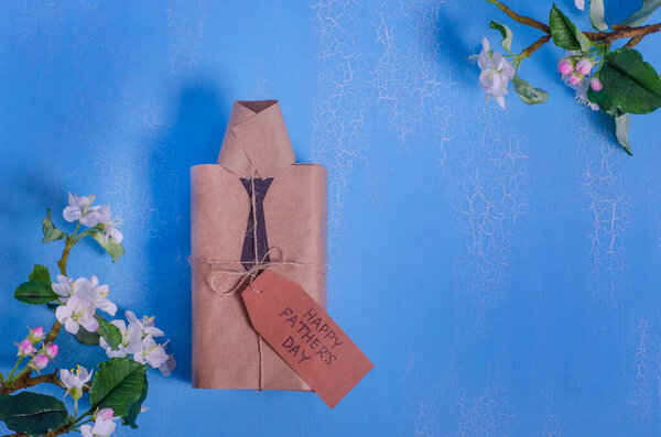 Концепция Дня отца. Счастливого дня отца. Подарочная коробка в виде рубашки на синем фоне с цветами с копировальным пространством. поздравительная открытка
