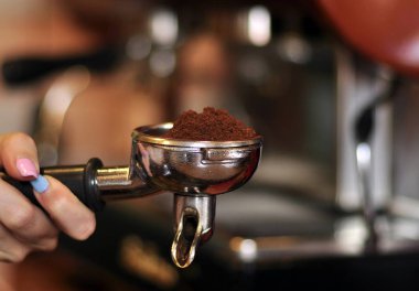 Yakından, güzel ve zarif espresso duble spout portafilter ile dolu güzel arabika kahve önce barista düz tamp mat ve mayalama ile. 