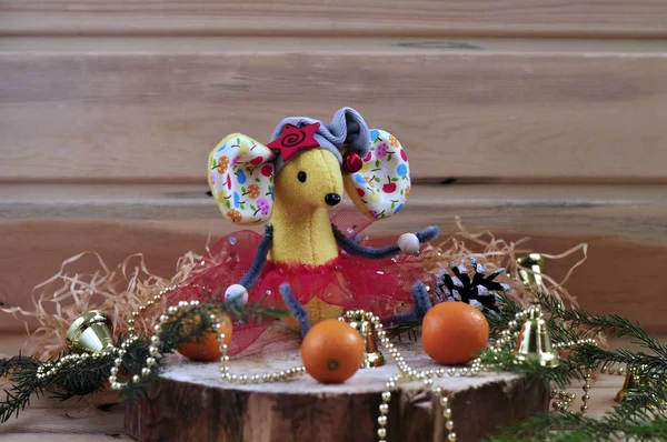 .Soft toy handmade yellow rat for Christmas. The symbol of The new year 2020 according to the Chinese horoscope on a wooden background with tangerines. Winter holiday