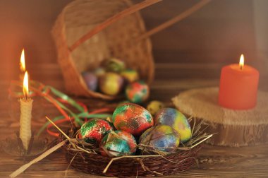 Ahşap bir arka planda sepete boyanmış Paskalya yumurtaları.