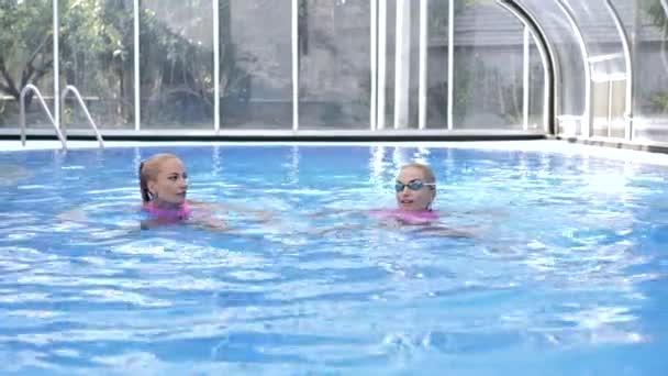 Dwie Bliźniaczki Różowych Strojach Kąpielowych Pływają Basenie Błękitną Wodą — Wideo stockowe