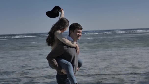 若いカップルは氷に覆われた川 晴れた春の日の隣をうろうろ — ストック動画