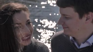 Date of a young couple on the river bank, in the background sun glare, sunny spring day